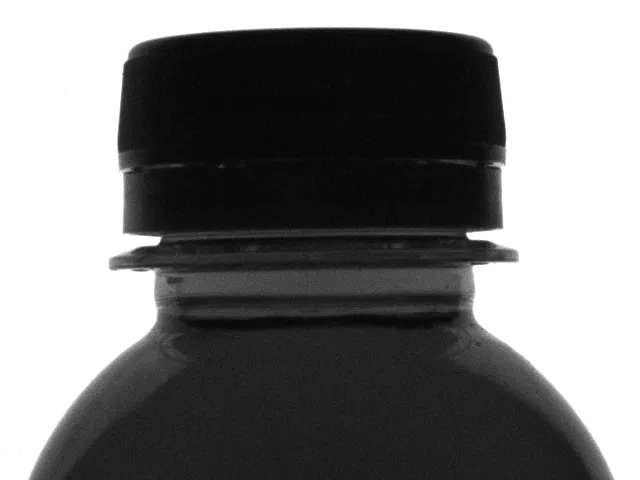 Botol teh kemasan dengan tutup, ring segel, dan level isi normal — dinyatakan lolos inspeksi.